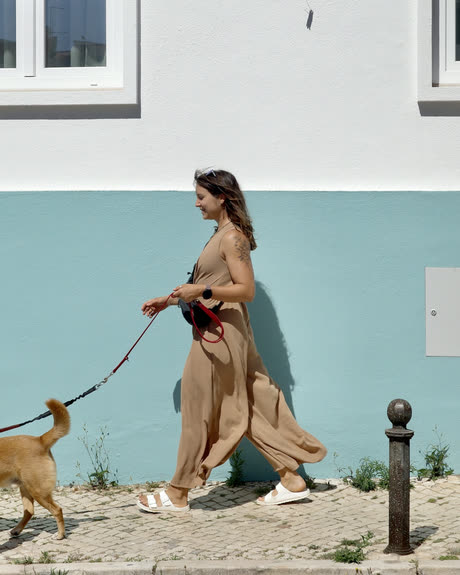 Zuza Zuber walking her dog along a turquoise wall in the Algarve